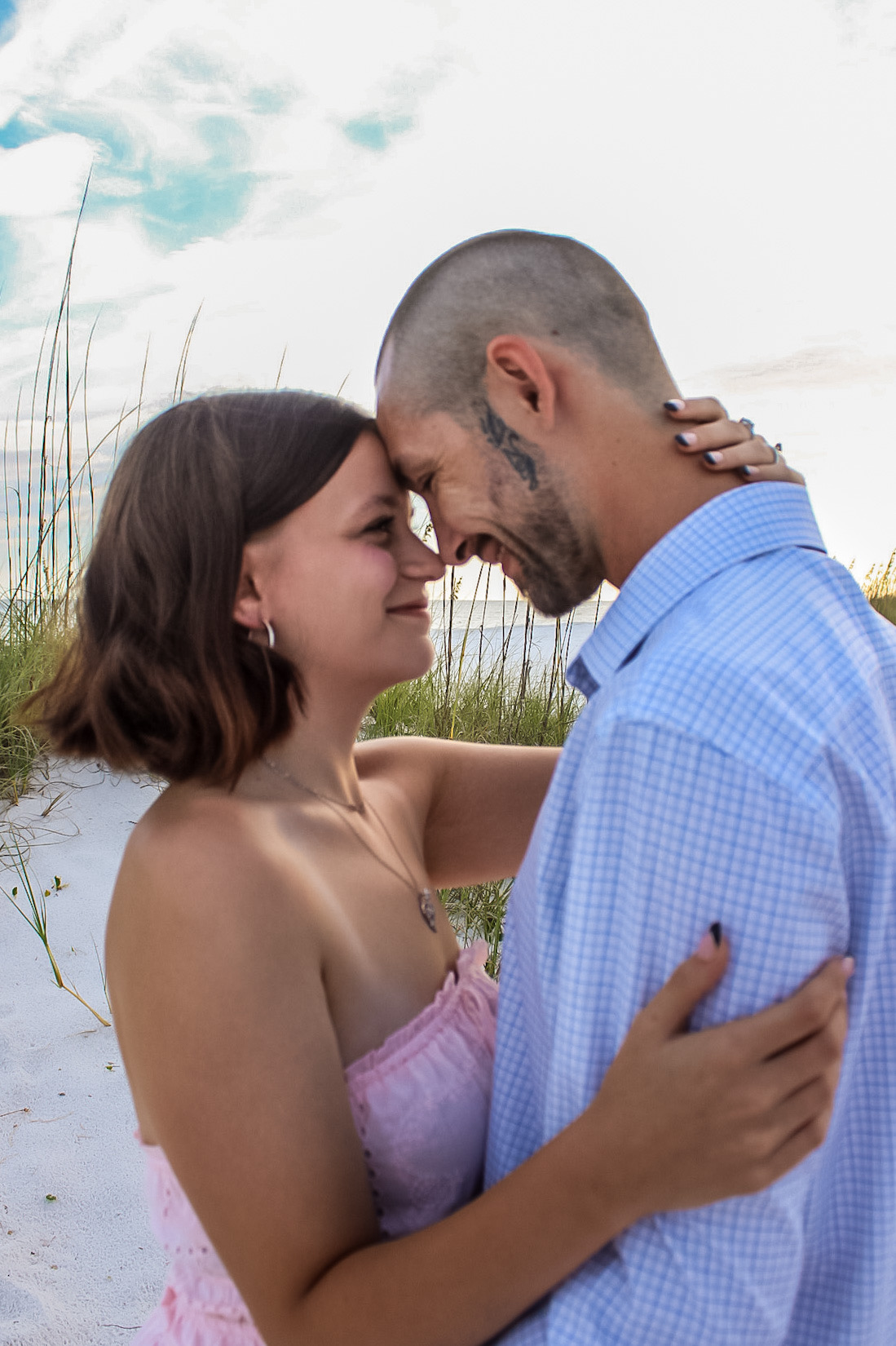 Couple sharing a close, relaxed moment among the beach dunes