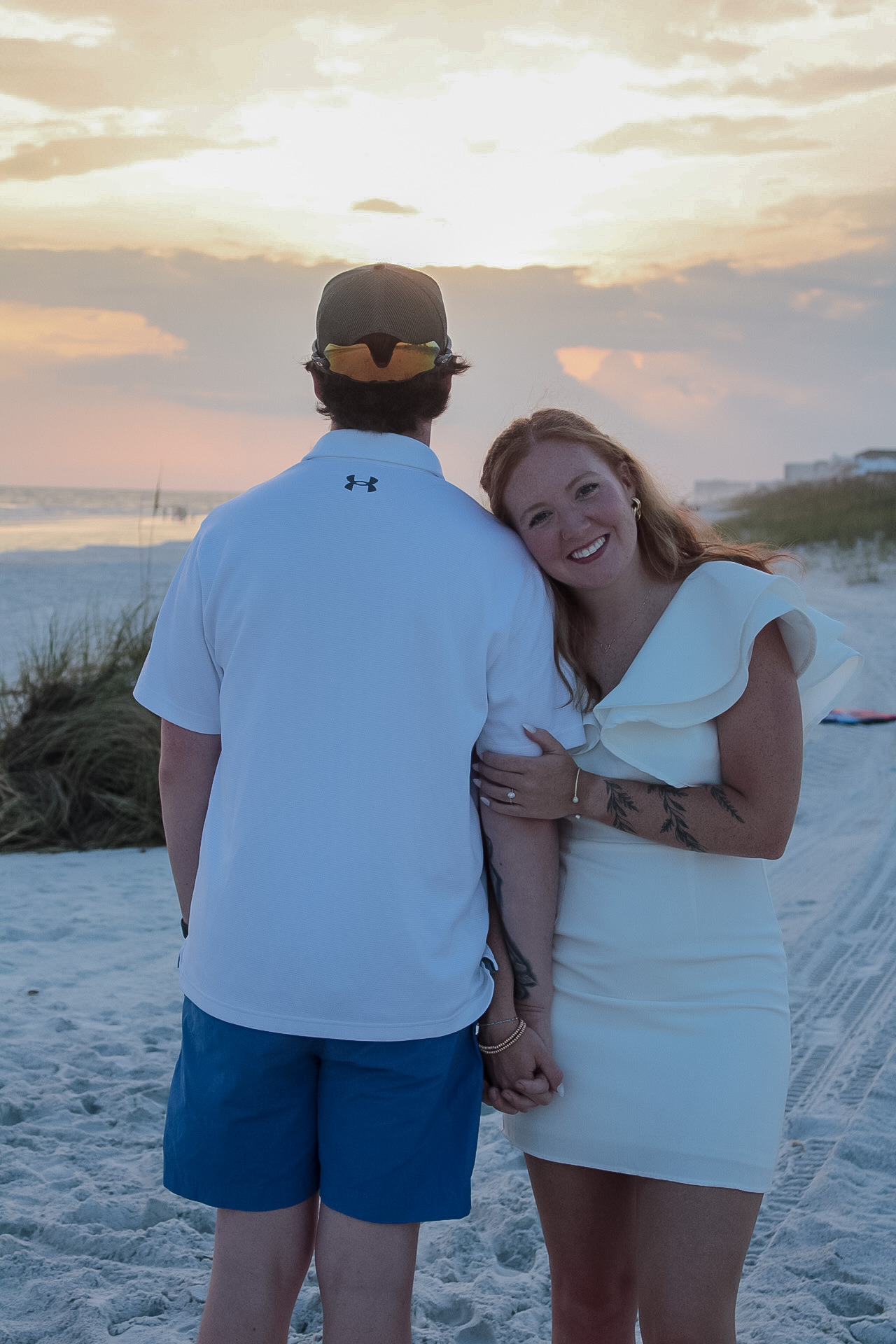 Couple holding hands during a colorful sunset beach portrait by Miranda Rae Photography