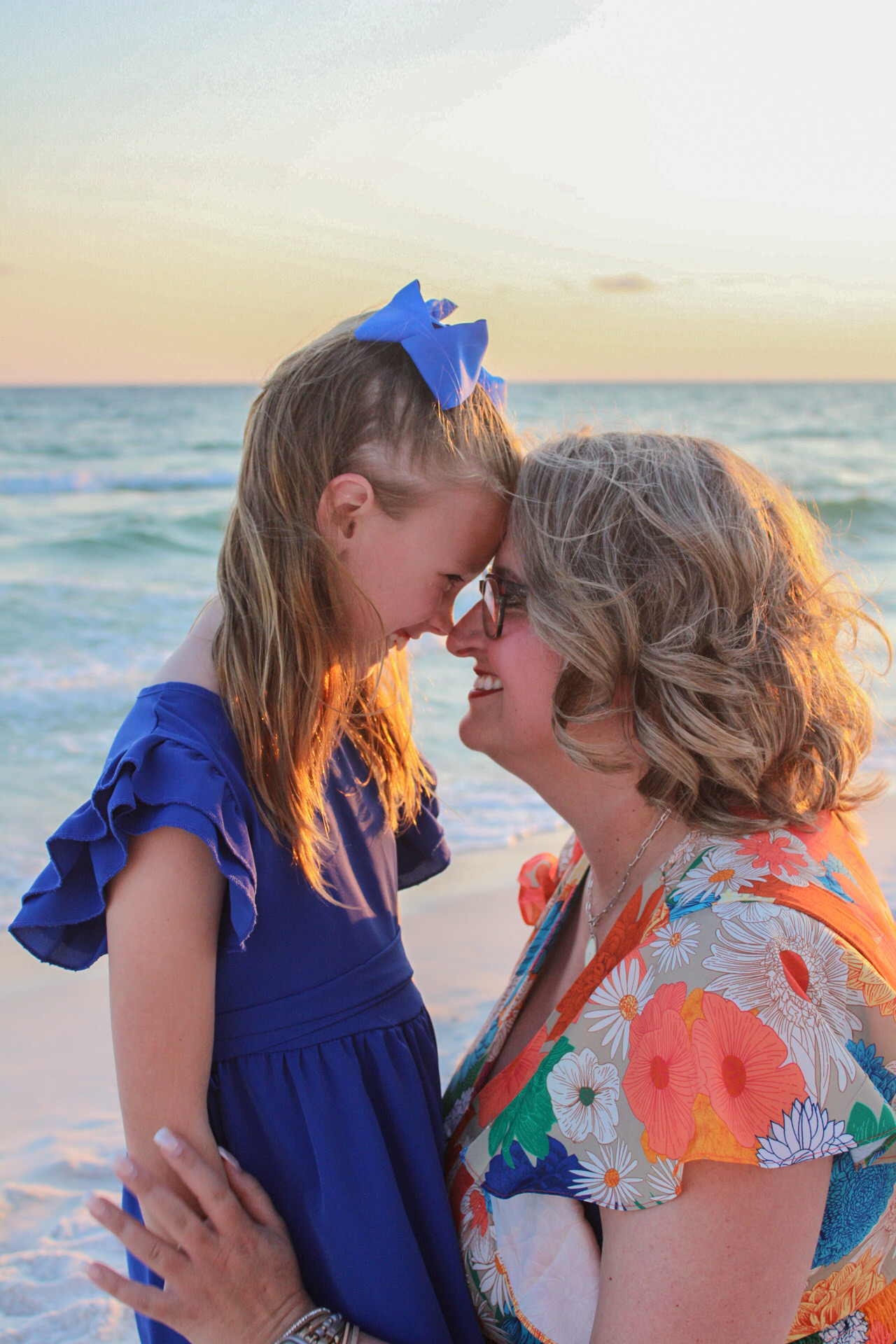 Mother and daughter sharing a warm moment at the shoreline