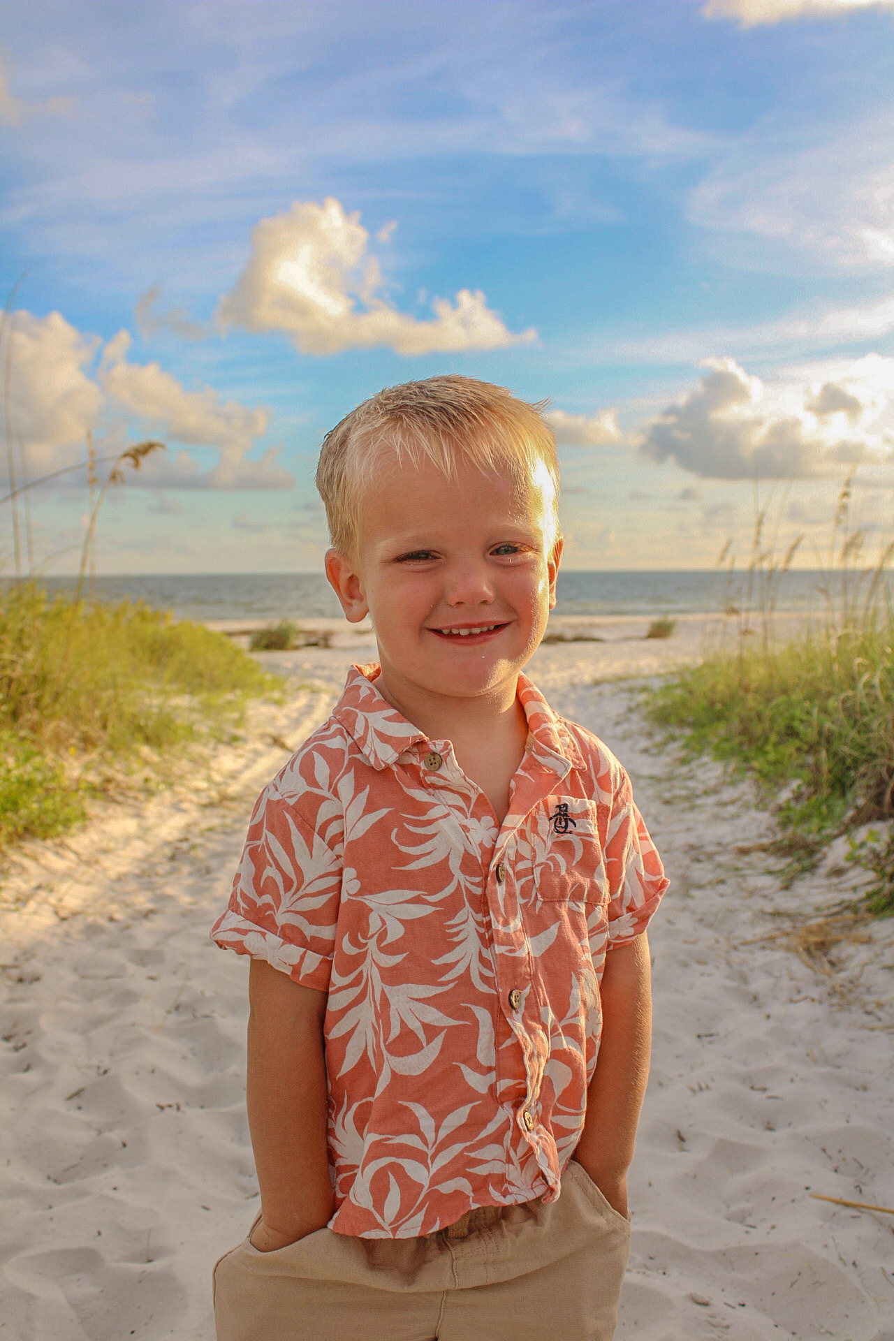 Young boy smiling in warm sunset light on a Gulf Coast beach